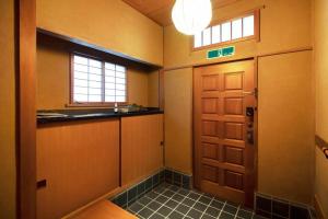 a hallway with a door and a window and a sink at Roopt仙台薬師堂 in Sendai