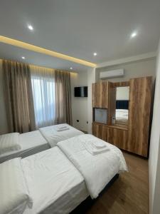 a bedroom with two beds and a large mirror at Villa Mefaja in Krujë