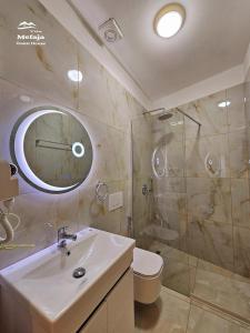 een badkamer met een wastafel, een douche en een toilet bij Villa Mefaja in Krujë