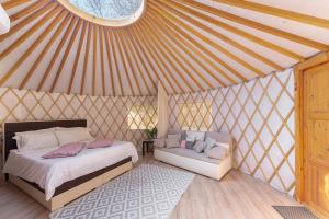 1 dormitorio con 1 cama y 1 sofá en una yurta en L.stile Glamping, en Portorož