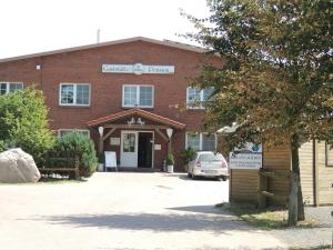 a brick building with a car parked in front of it at Reitanlage Plath in Timmendorf