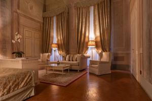 a bedroom with a bed and two chairs and a table at Palazzo Guicciardini in Florence