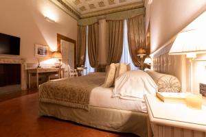 een slaapkamer met een groot bed, een bureau en een bureau bij Palazzo Guicciardini in Florence