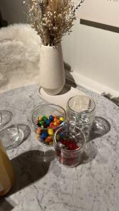 una mesa con tazones de vidrio y un jarrón de flores en Suite Haspengouw, en Sint-Truiden