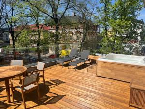 - Terraza con bañera de hidromasaje, sillas y mesa en Apartmány Vila Terasy, en Liberec