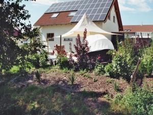 une maison dotée d'un toit avec des panneaux solaires dans l'établissement Ferienwohnung für Nichtraucher am Ortsrand mit Balkon, 4 Sterne DTV Klassifizierung, à Bad Buchau