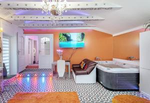 un ampio bagno con vasca e lampadario a braccio di President Apartments villa SPA a Vilnius
