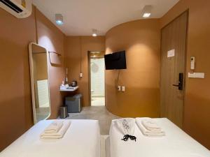 バンコクにあるThe Palette Bangkok Hotel - Self check-in after 10 pmのベッド1台と壁掛けテレビが備わる客室です。