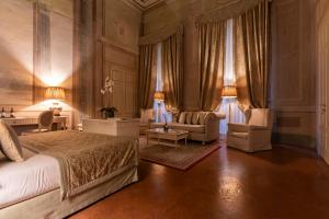 ein Schlafzimmer mit einem Bett, einem Sofa und Stühlen in der Unterkunft Palazzo Guicciardini in Florenz