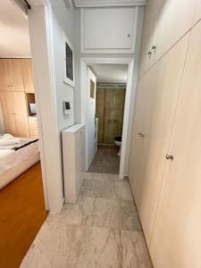 einen Flur eines Zimmers mit einem Bett und einem Bad in der Unterkunft Alexandra's View in Piräus