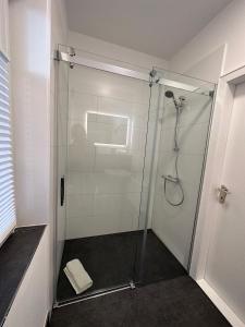 y baño con ducha y puerta de cristal. en Ruhige, kleine Unterkunft in Weyhe, Nähe Bremen, en Weyhe
