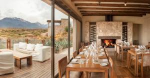 a dining room with tables and a fireplace at Bodega Alpasión Lodge y Glamping in Tunuyán