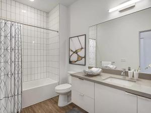 a white bathroom with a toilet and a tub and a sink at Golden west homes in Yauco