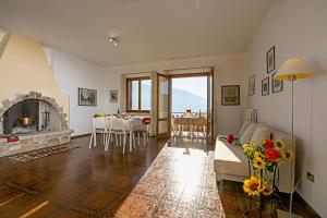 a living room with a fireplace and a table with chairs at Balcone Panoramico sul Garda in Tremosine Sul Garda