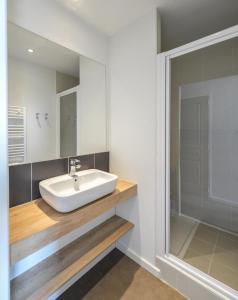 La salle de bains est pourvue d'un lavabo et d'un miroir. dans l'établissement Villages Clubs du Soleil - OZ EN OISANS, à Oz