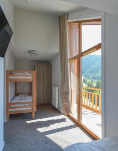 a bedroom with a balcony with a bed and a window at Villages Clubs du Soleil - OZ EN OISANS in Oz