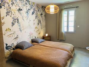 sypialnia z dużym łóżkiem i tapetą w kwiaty w obiekcie Le Saint Marin w mieście Chatuzange-le-Goubet