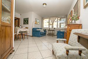 een woonkamer met blauwe stoelen en een tafel bij Riva Centro Apartment in Riva del Garda