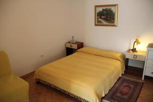 a small bedroom with a bed and a chair at Ferienwohnung in Novigrad mit privatem Parkplatz in Karpinjan