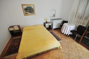 a bedroom with a bed and a table and a chair at Ferienwohnung in Novigrad mit privatem Parkplatz in Karpinjan