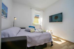 a bedroom with a bed and a tv on the wall at Nido sui Tetti di Riva del Garda in Riva del Garda