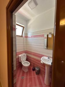 uma casa de banho com um WC e um lavatório em Evelina Ernild Rooms em Saranda