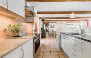 cocina con armarios blancos y suelo de baldosa en 7 Bedroom Nice Home In Rnde en Rønde