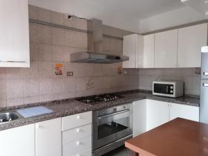 a kitchen with white cabinets and a stove top oven at maria antonietta in Urbino