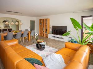 een woonkamer met een oranje bank en een eetkamer bij at the weir Modern retreat in Allersberg