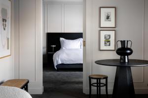 Schlafzimmer mit einem Bett, einem Tisch und einem Stuhl in der Unterkunft Pillows Luxury Boutique Hotel aan de IJssel in Deventer