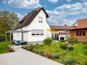 ein weißes Haus mit einem Garten davor in der Unterkunft Sun Garden Modern retreat in Allersberg