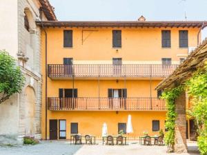 un bâtiment orange avec des tables et un balcon dans l'établissement Palazzo Barbò Modern retreat, à Pumenengo