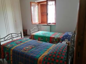 1 dormitorio con 2 camas y mantas verdes y azules en maria antonietta, en Urbino