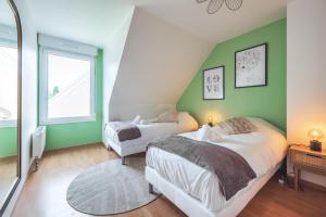 - 2 lits dans une chambre aux murs verts dans l'établissement Le Serenity - Maison avec terrasse pour 8 personnes, à Haguenau