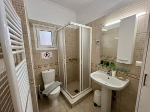 a bathroom with a toilet and a sink and a shower at Marina's House in Parga