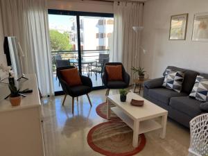 ein Wohnzimmer mit einem Sofa, Stühlen und einem Tisch in der Unterkunft Appartement Pedraza in Albir