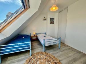 a attic room with two beds and a window at Quiberon - Maison 3 pièces - 6 pers - Calme avec parking - FR-1-478-61 in Quiberon