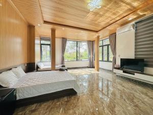 um quarto com uma cama e uma televisão de ecrã plano em HeniSi Hotel Măng Đen (HeniSi 2) em Kon Von Kla