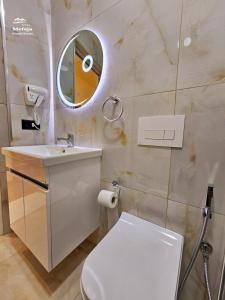 ein Badezimmer mit einem WC, einem Waschbecken und einem Spiegel in der Unterkunft Villa Mefaja in Kruja