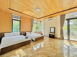 um quarto grande com 2 camas e uma televisão em HeniSi Hotel Măng Đen (HeniSi 2) em Kon Von Kla