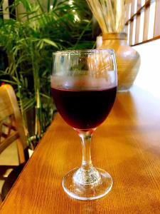 a glass of red wine sitting on a table at Family Hotel Zhangjiajie in Zhangjiajie