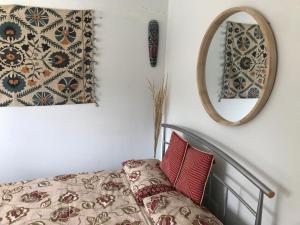 um quarto com uma cama e um espelho em Cozy double bedroom in stunning Bungalow on River Thames - near Thorpe Park/Royal Holloway University/20mins from Heathrow em Staines upon Thames