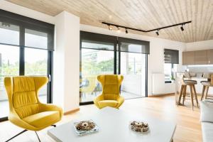 ein Wohnzimmer mit 2 gelben Stühlen und einem Tisch in der Unterkunft The HostMaster Persephone Yellow Opulence 2nd floor in Athen
