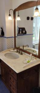 ein Bad mit einem Waschbecken und einem Spiegel in der Unterkunft Art Cottage in Pontlevoy