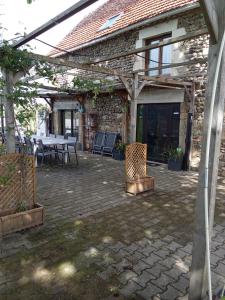 a patio with a table and chairs and a building at Au Garrine in Puybrun