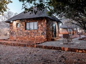 a small stone building with a grass roof at Thaba eNtle Private Boutique Game Farm in Thabazimbi