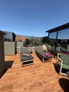 - un patio avec des chaises longues et des chaises sur une terrasse dans l'établissement Appartement Luxueux au Rooftop à Guéliz, à Marrakech