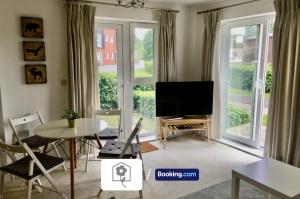 a living room with a tv and a table and chairs at Garden Apartment near New Forest By Your Stay Solutions Short Lets & Serviced Accommodation Netley Southampton With Free Wi-Fi in Totton