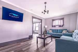 a living room with a blue couch and a table at Spacious 6BR 2Bath Close the Falls in Niagara Falls