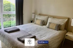 a bedroom with a large bed with a window at Garden Apartment near New Forest By Your Stay Solutions Short Lets & Serviced Accommodation Netley Southampton With Free Wi-Fi in Totton